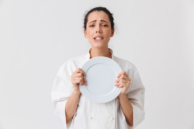 Retrato de una mujer joven seductora con platos