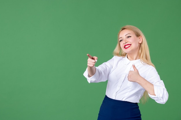 retrato, de, mujer joven, señalar, en, pared verde, profesor, estudiante, colegio, libro escolar