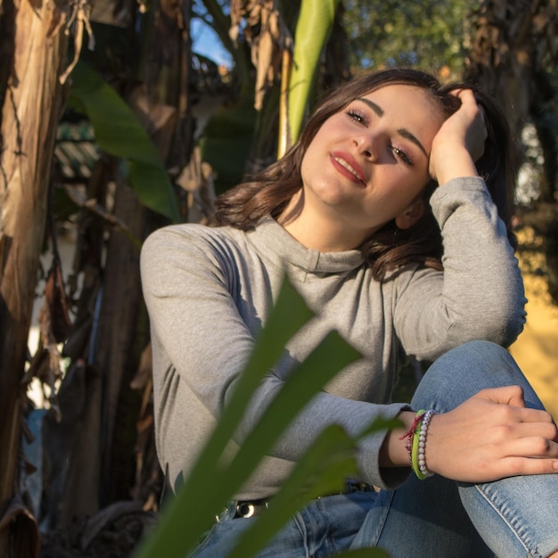 Foto retrato de una mujer joven sentada al aire libre