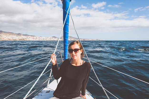 Foto retrato de una mujer joven sentada en un barco en el mar