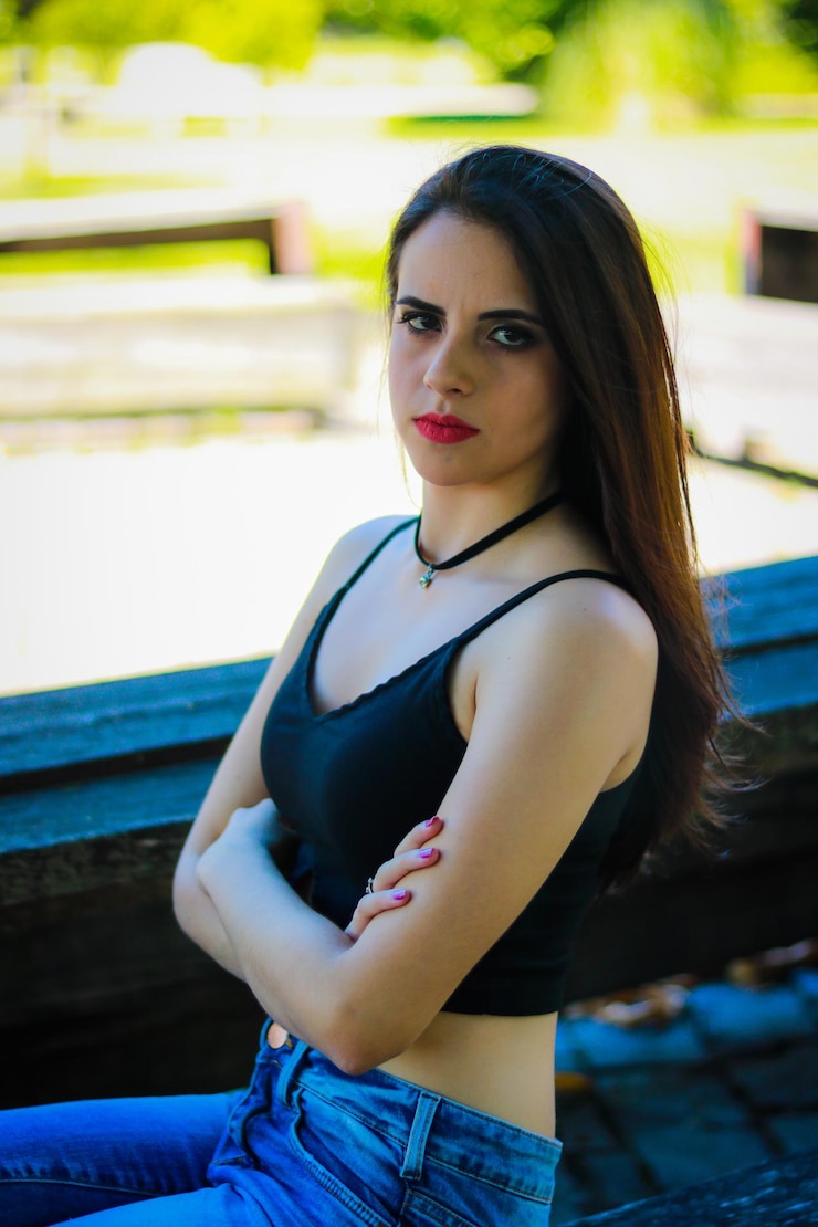 Foto retrato de una mujer joven sentada con los brazos cruzados