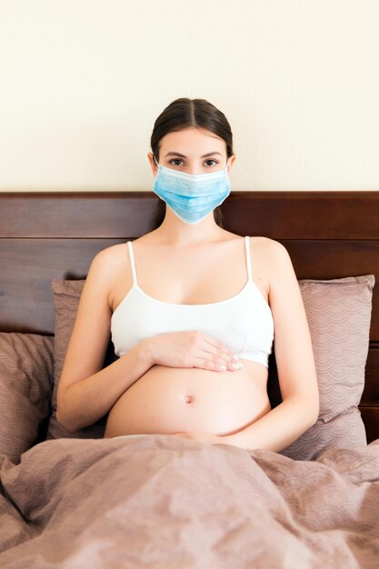 Foto retrato de una mujer joven sentada en la cama