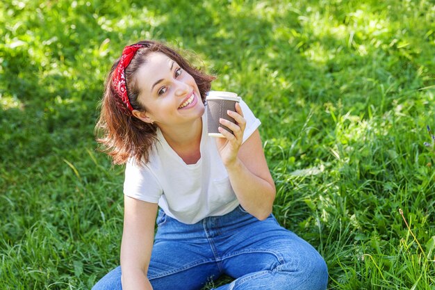 Retrato de una mujer joven sentada en un campo de hierba