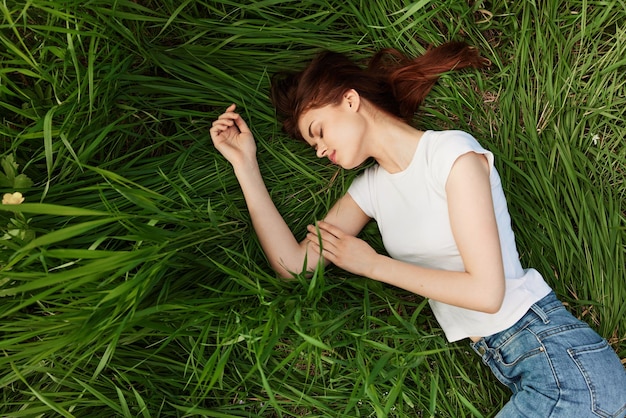 Retrato de una mujer joven sentada en un campo de hierba