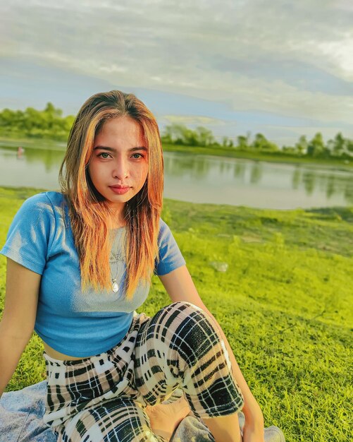 Retrato de una mujer joven sentada en el campo