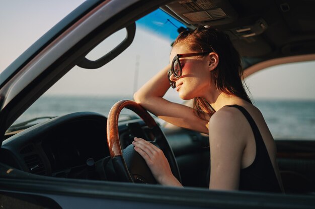 Foto retrato de una mujer joven sentada en un coche