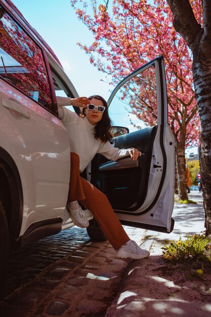 Foto retrato de una mujer joven sentada en un coche