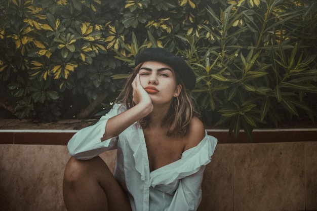 Retrato de una mujer joven sentada junto a las plantas