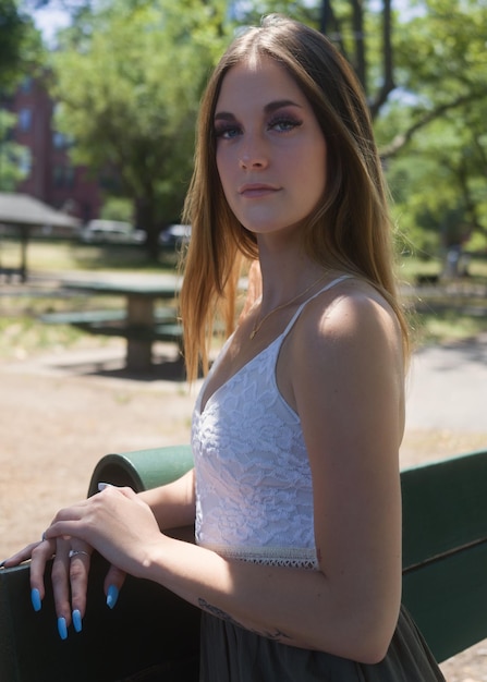 Foto retrato de una mujer joven sentada en un parque