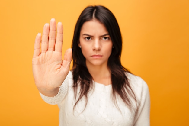 Retrato de una mujer joven seria mostrando parada