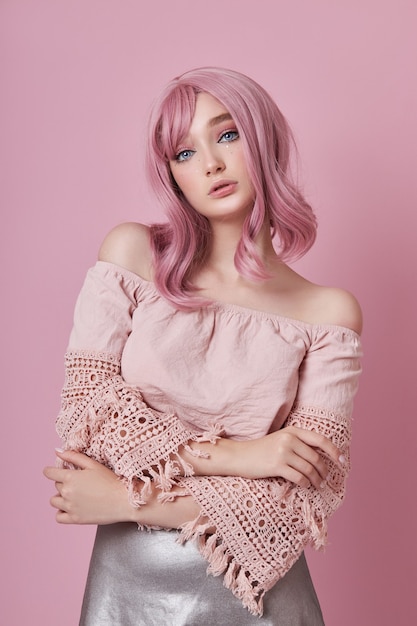 Retrato de una mujer joven sexy con cabello rosado. Peinado perfecto y coloración del cabello. Chica con hermosos ojos azules y cabello largo rosa