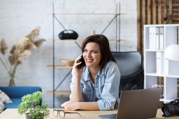 Retrato de mujer joven con smartphone y sonriendo