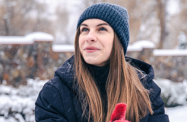 Retrato de una mujer joven con un sombrero y una chaqueta en invierno