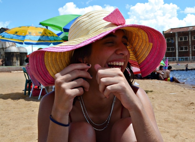 Foto retrato de una mujer joven con sombrero en la playa