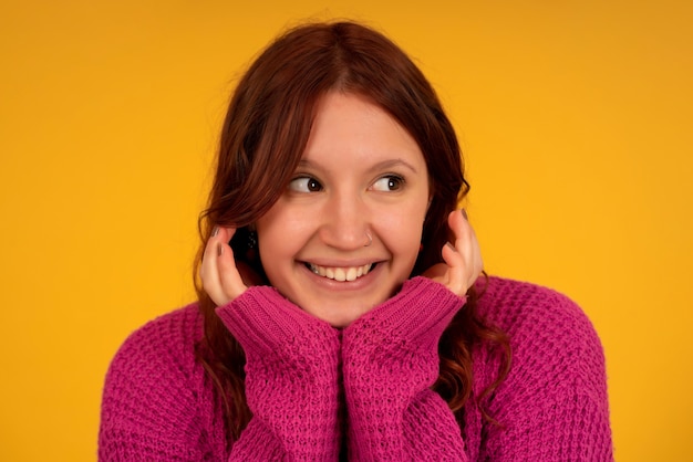 Retrato de una mujer joven sonriendo mientras está de pie contra el fondo aislado.