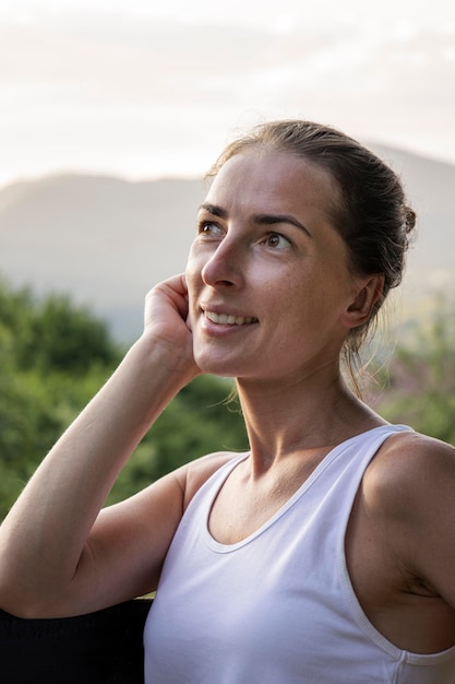 Retrato de una mujer joven sonriente sobre un fondo de montañas