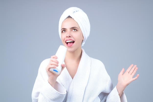 Retrato de mujer joven sostenga la botella de champú y acondicionador producto de belleza botella de bálsamo mujer joven w