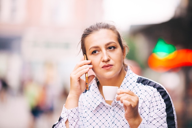 Foto retrato de una mujer joven sosteniendo un café