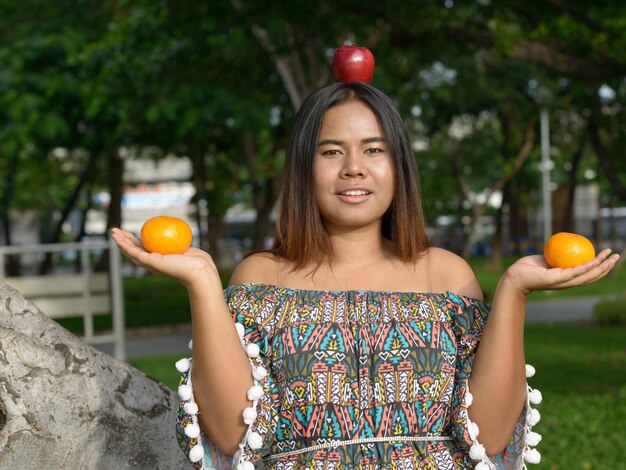 Foto retrato de una mujer joven sosteniendo frutas