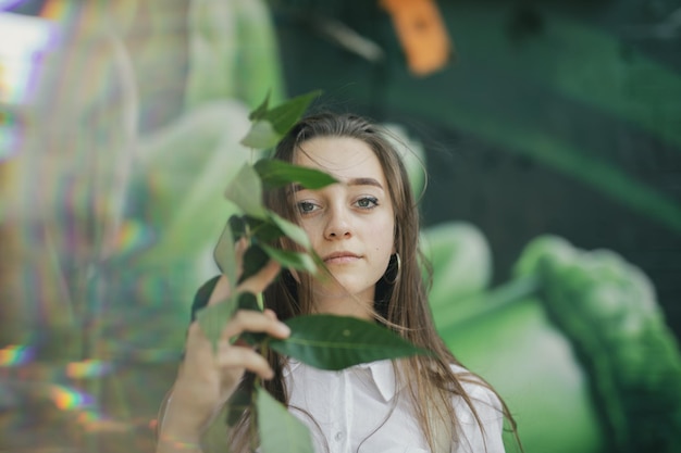 Retrato de una mujer joven sosteniendo hojas al aire libre