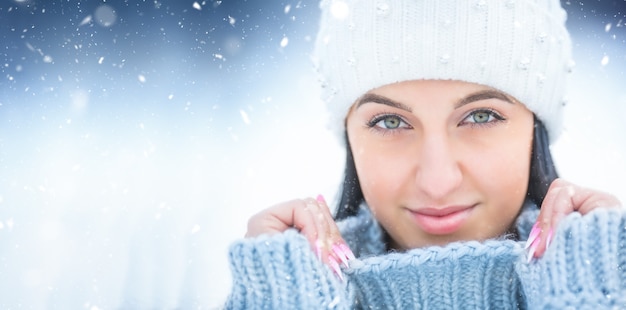 Retrato de mujer joven con suéter de ropa de invierno y gorra.