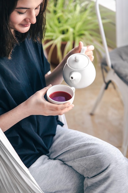 retrato, de, un, mujer joven, con, un, taza de té, en, un, café