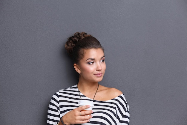 Retrato de mujer joven con taza de té o café.