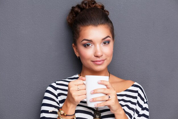 Retrato de mujer joven con taza de té o café.