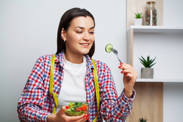 Foto retrato de una mujer joven con un tazón de ensalada