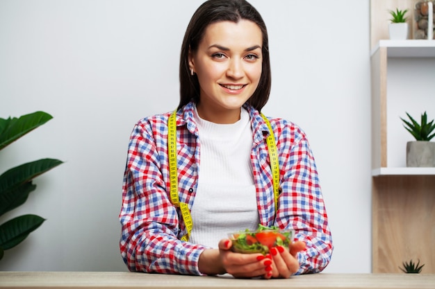 Retrato de una mujer joven con un tazón de ensalada