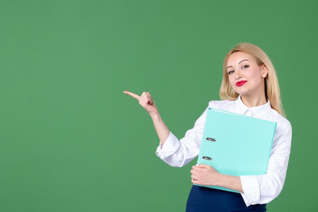 retrato, de, mujer joven, tenencia, documento, pared verde, escuela, lección, profesor, estudiante