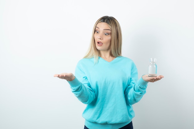 Retrato, de, mujer joven, tenencia, jarra de vidrio, de, agua, en, mano