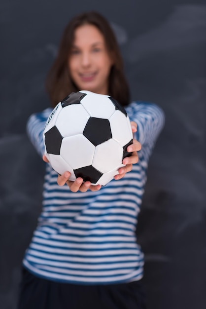 retrato, de, un, mujer joven, tenencia, un, pelota del fútbol, delante de, tiza, tablero de dibujo