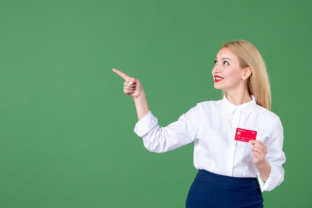 retrato, de, mujer joven, tenencia, tarjeta bancaria, en, pared verde, dinero, profesor, escuela