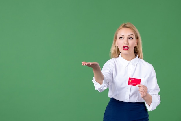 retrato, de, mujer joven, tenencia, tarjeta de crédito, y, señalar, pared verde, maestro, banco, dinero, escuela