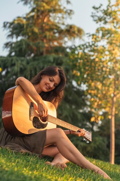 Foto retrato de una mujer joven tocando la guitarra