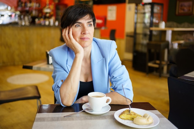 Foto retrato de una mujer joven tomando el desayuno