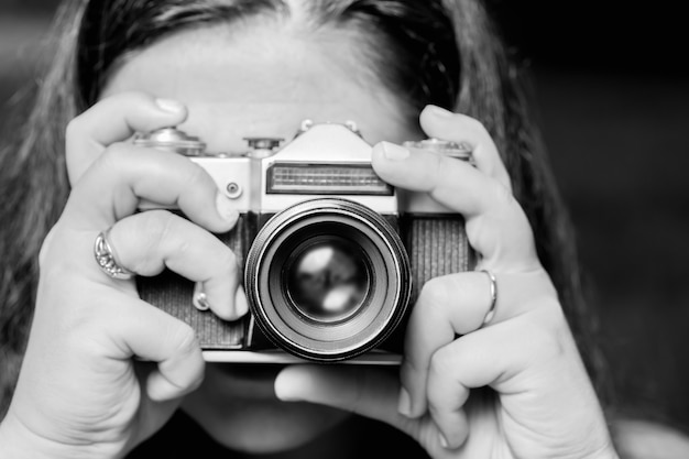 Retrato de mujer joven tomando fotos con cámara retro vintage.