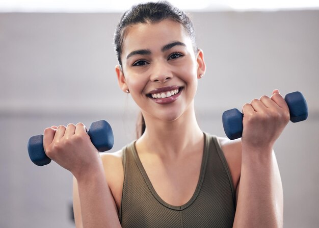 retrato, de, un, mujer joven, trabajando, con, dumbbell, pesos, en, un, gimnasio