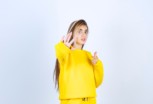 Retrato de mujer joven en traje amarillo posando para la cámara