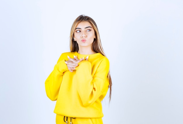 Retrato de mujer joven en traje amarillo posando y de pie