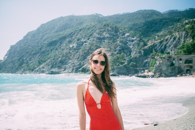 Retrato de una mujer joven con traje de baño rojo en la playa
