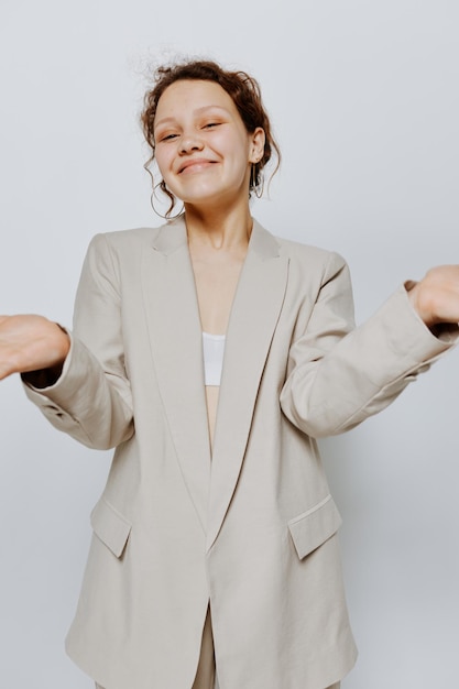 Retrato de una mujer joven traje clásico moda posando divertido fondo claro inalterado