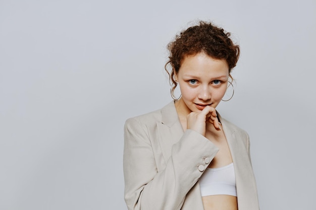 Retrato de una mujer joven traje clásico moda posando divertido fondo claro inalterado