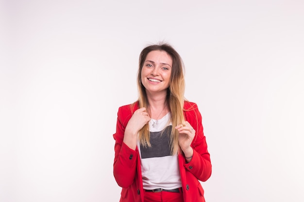 Retrato de mujer joven con un traje rojo posando sobre fondo blanco con espacio de copia.