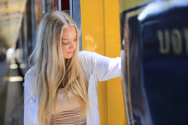 Foto retrato de una mujer joven en un tren de espera en la estación