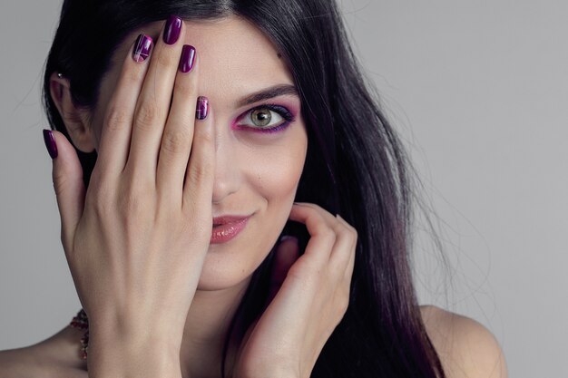 Retrato de mujer joven con uñas moradas