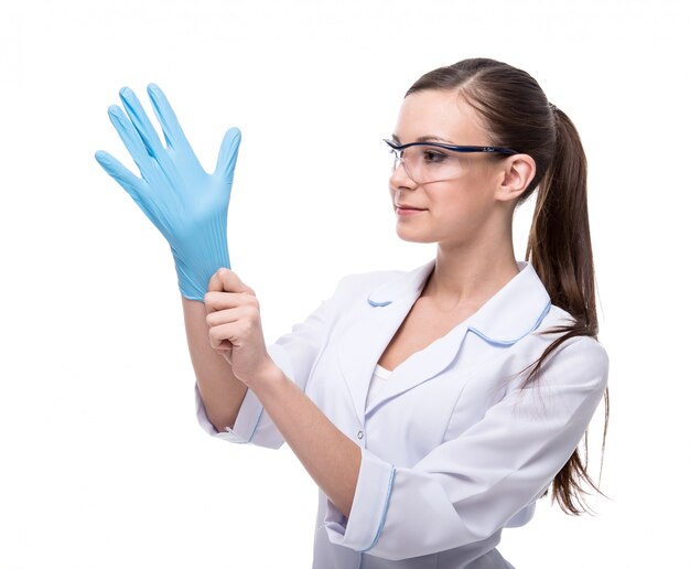 Retrato de una mujer joven en uniforme médico y guantes.