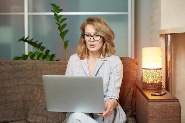 Retrato de una mujer joven usando una computadora portátil en casa