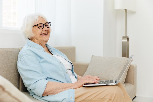 Retrato de una mujer joven usando una computadora portátil en casa